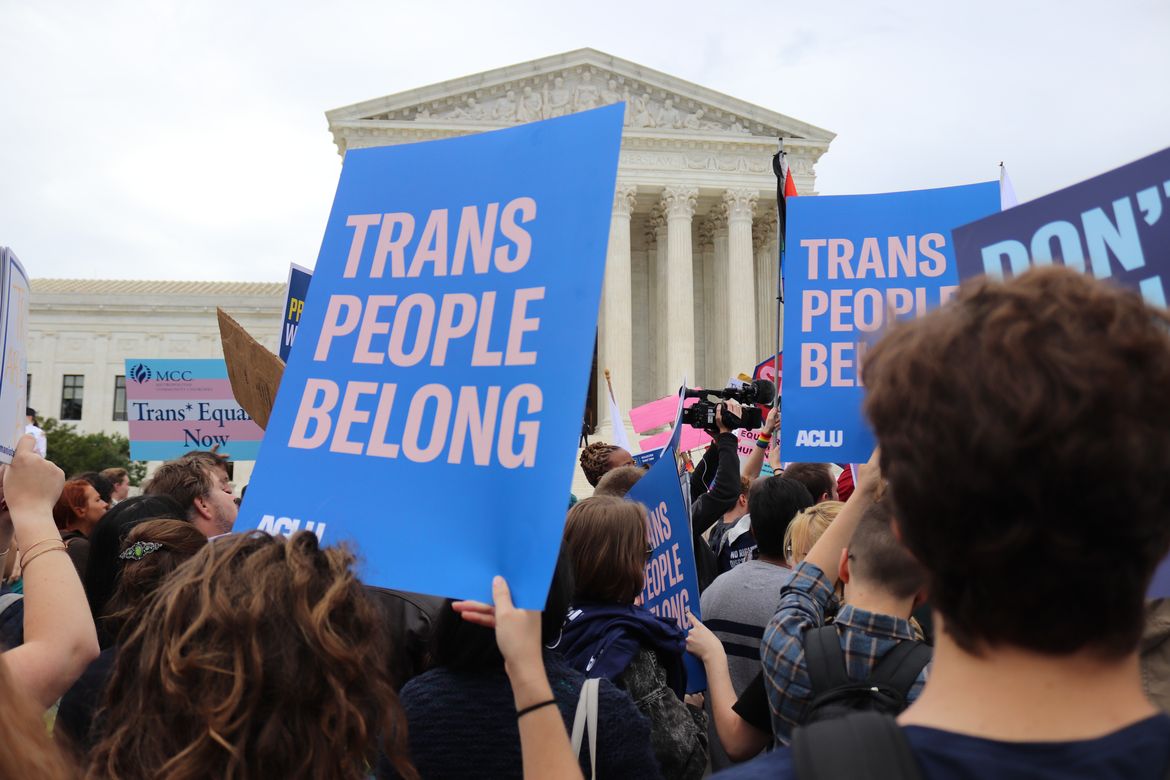 Demonstrators hold signs in front of the U.S. Supreme Court in support of transgender rights during a 2019 rally