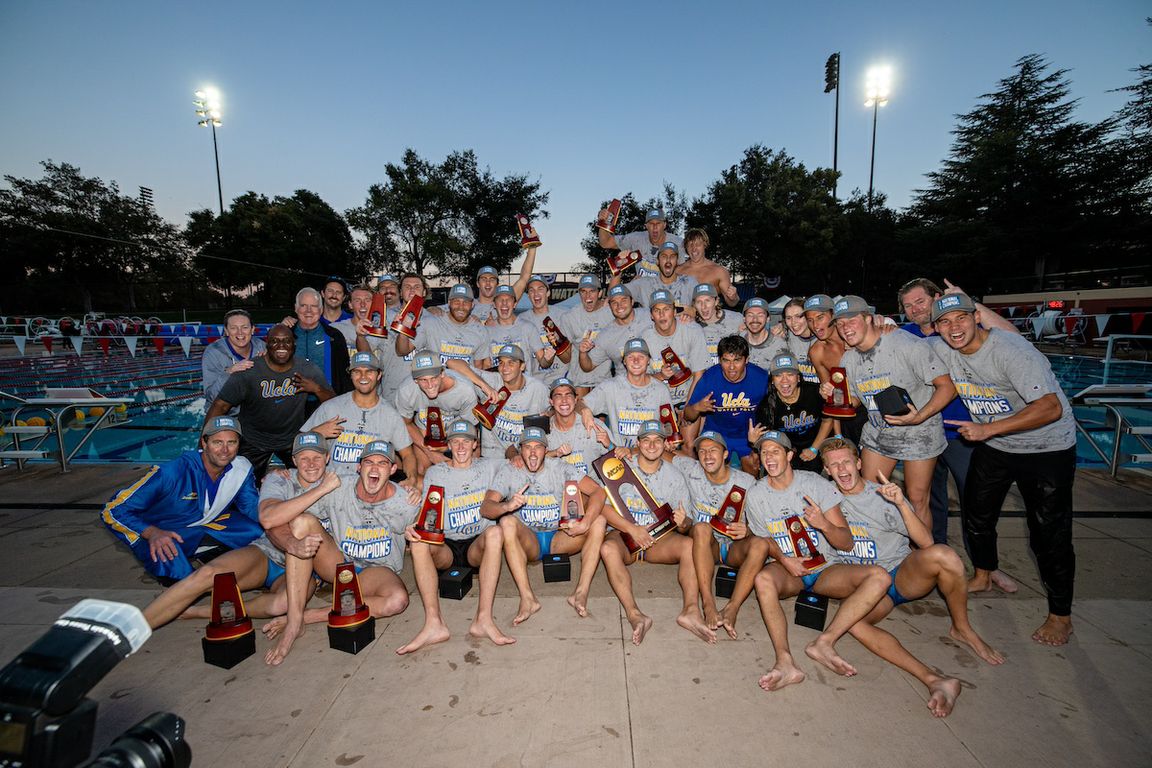 UCLA men&#039;s water polo team pose together, smiling and holding their medals, celebrating their success.