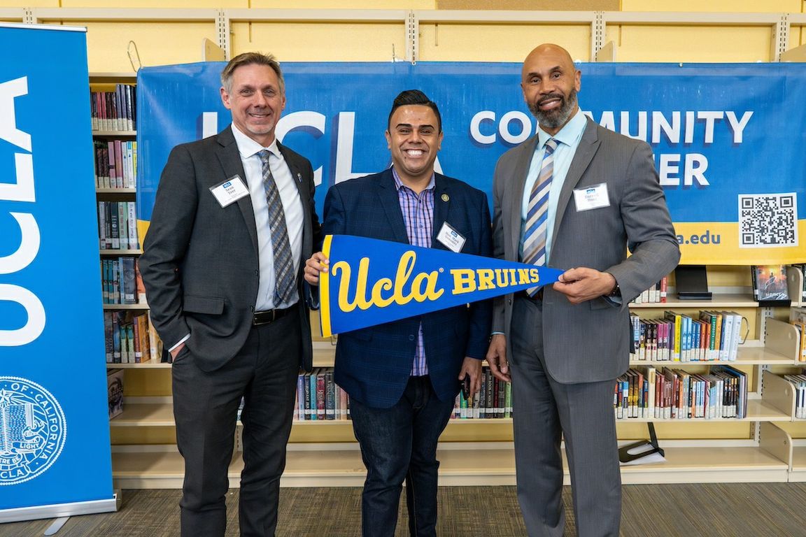 Left to right: Sean Teer, principal of Downtown Magnets High School; California Assemblymember Mark Gonzalez; and UCLA Interim Chancellor Darnell Hunt with a “UCLA community partner” banner