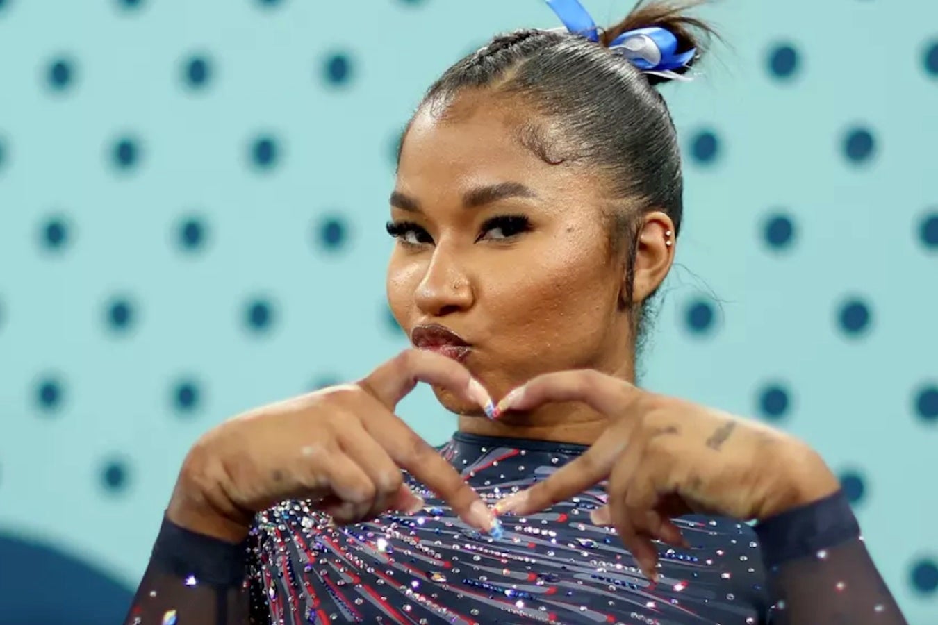 Gymnast Jordan Chiles makes a heart sign with her hands