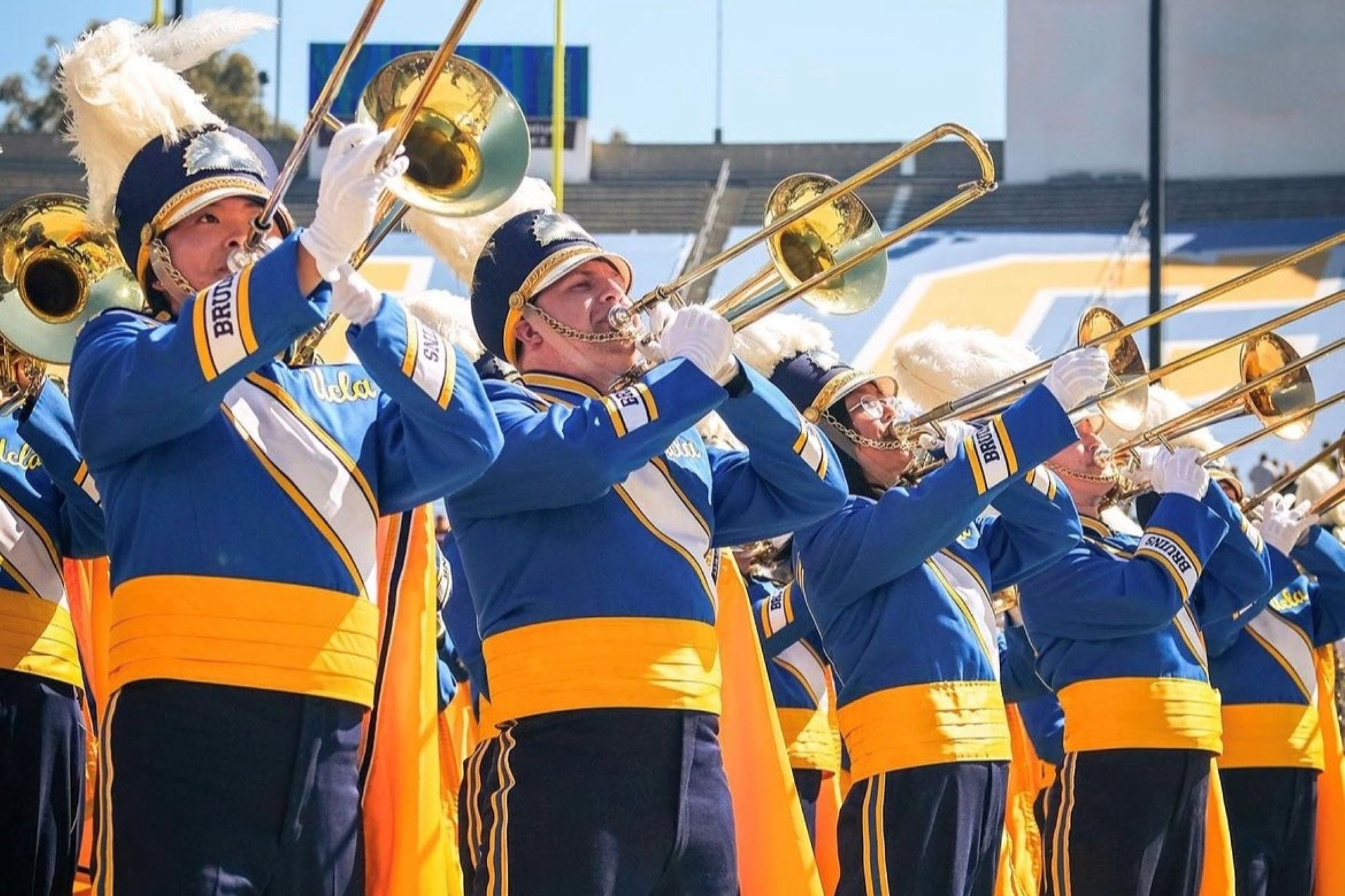 Row of trombone players in blue and gold band uniforms perform at Rose Bowl 