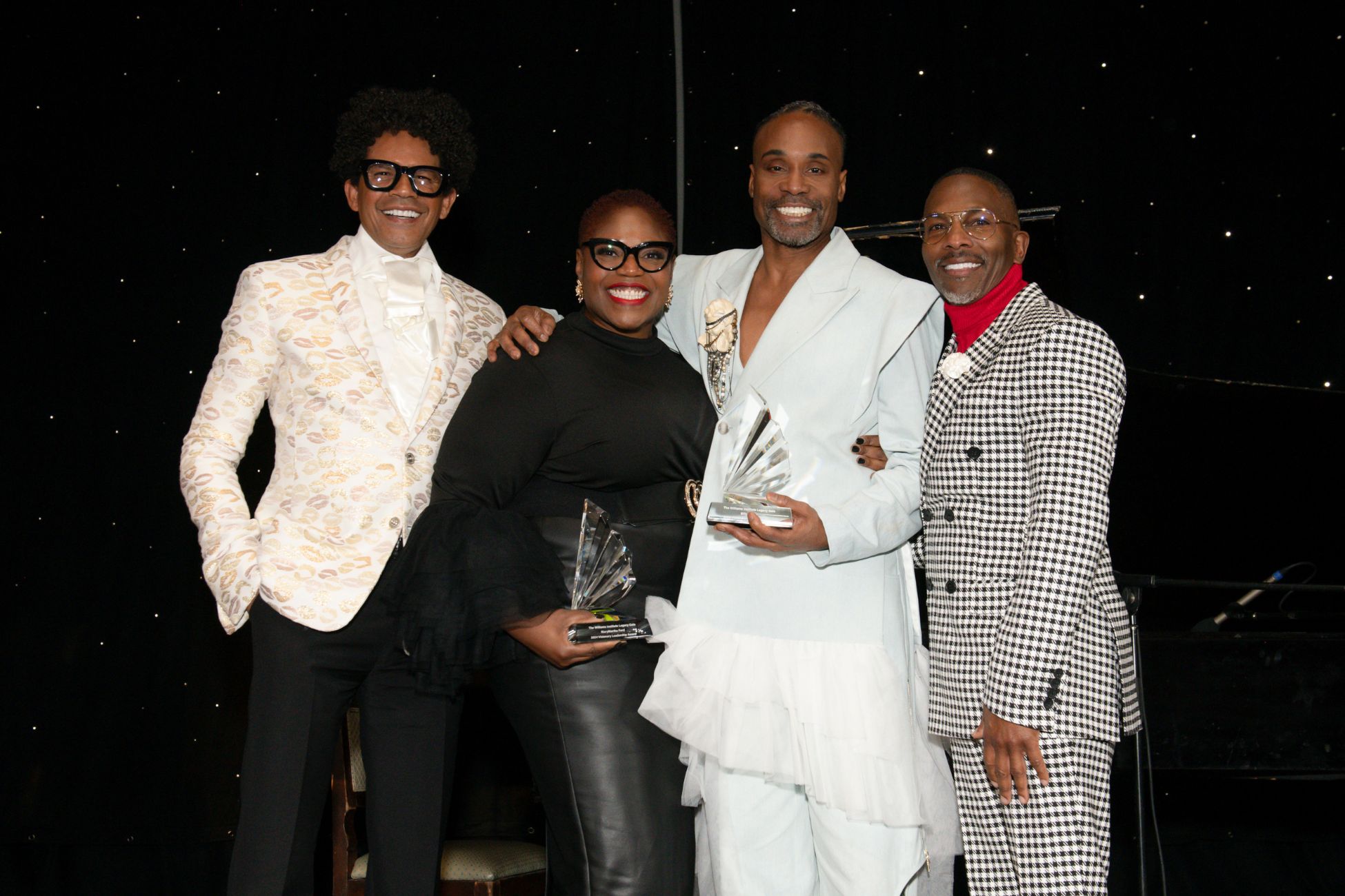 Three African American men and one African American woman smile at camera; two hold crystal awards