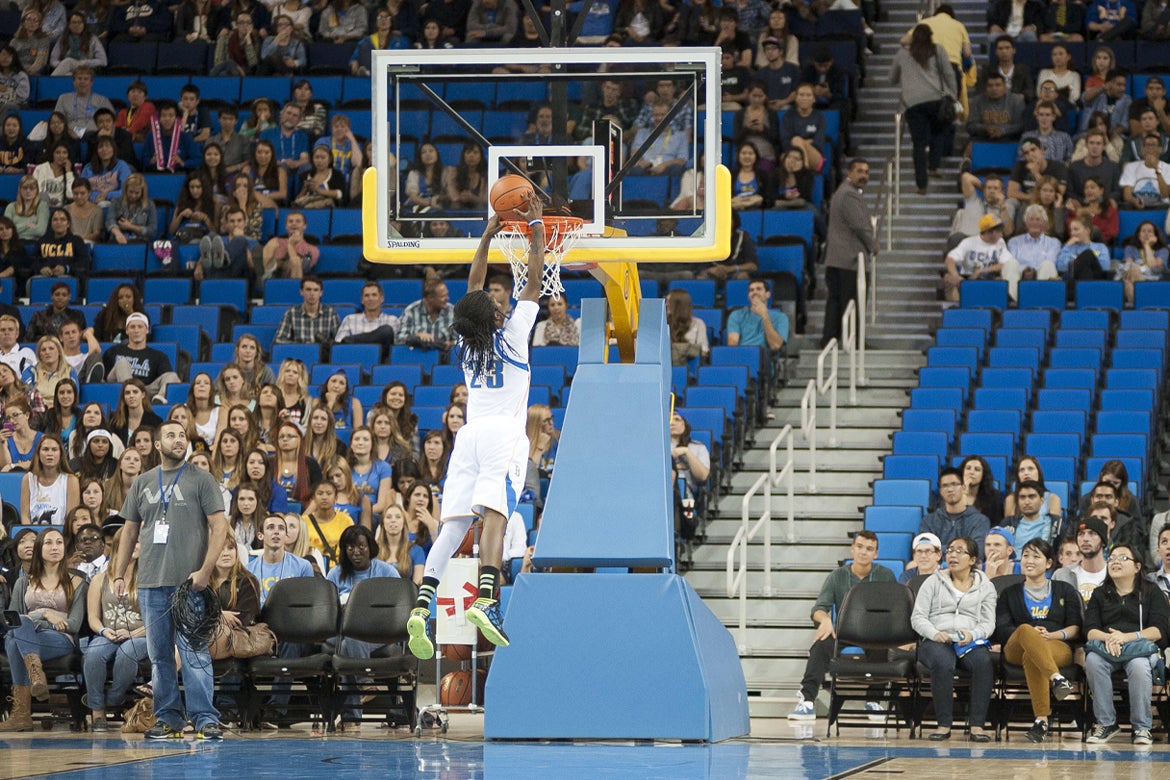 UCLA Woman Basketball player dunking a basketball in hoop