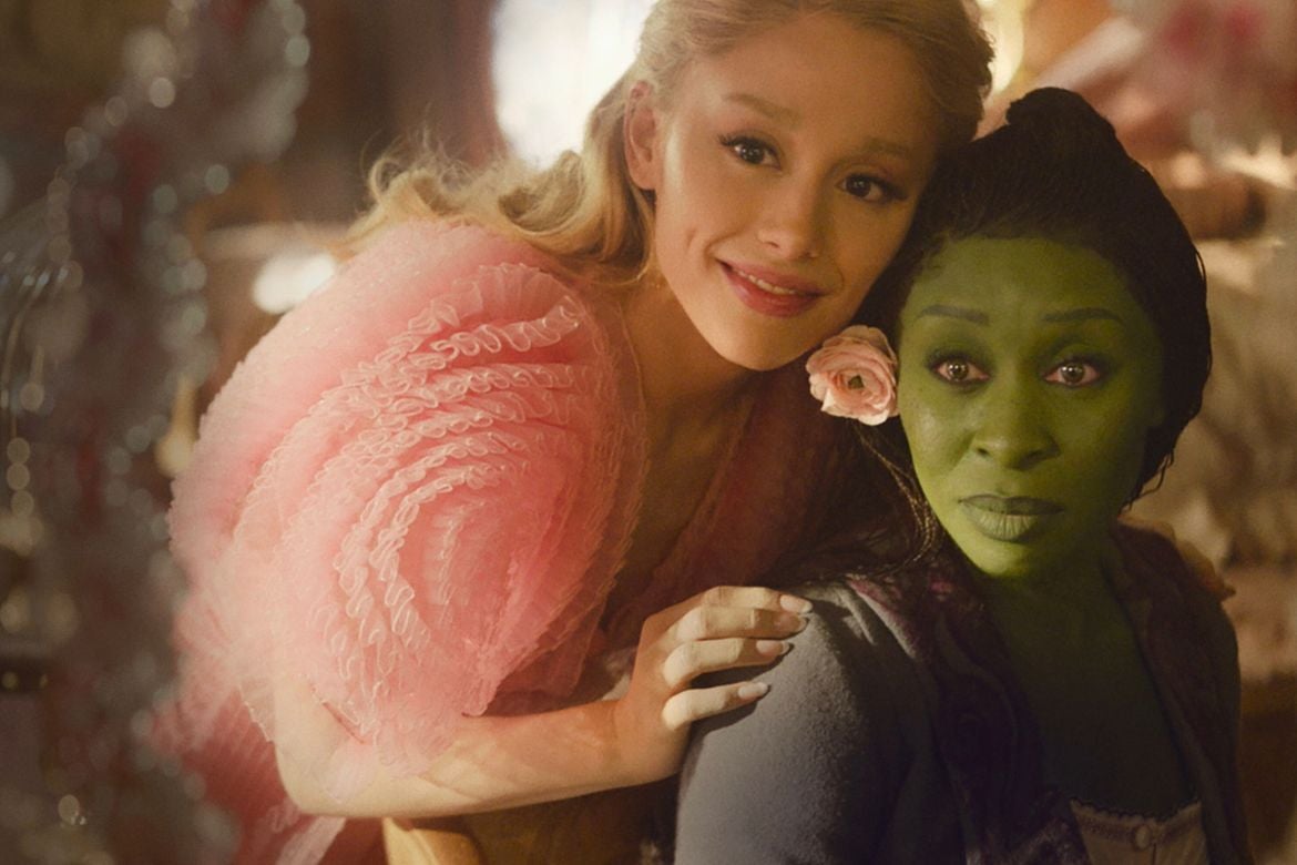 “Wicked” actors Ariana Grande and Cynthia Erivo look in a mirror in one of the film’s scenes