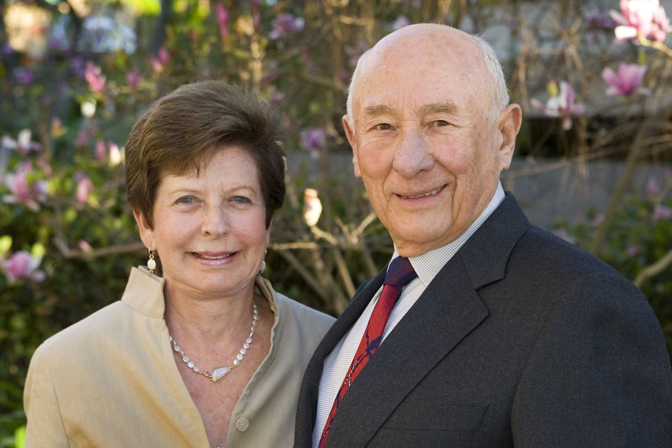 Couple Renee and Meyer Luskin standing in front of a tree, dressed in formal attire.